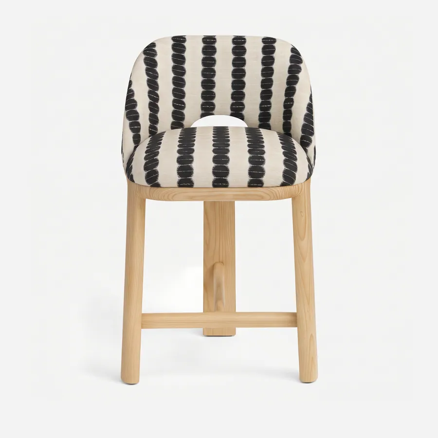 Eden Barstool barstool — ash wood frame with four round legs joined by stretchers, upholstered in pattern fabric, with a curved back that has…
