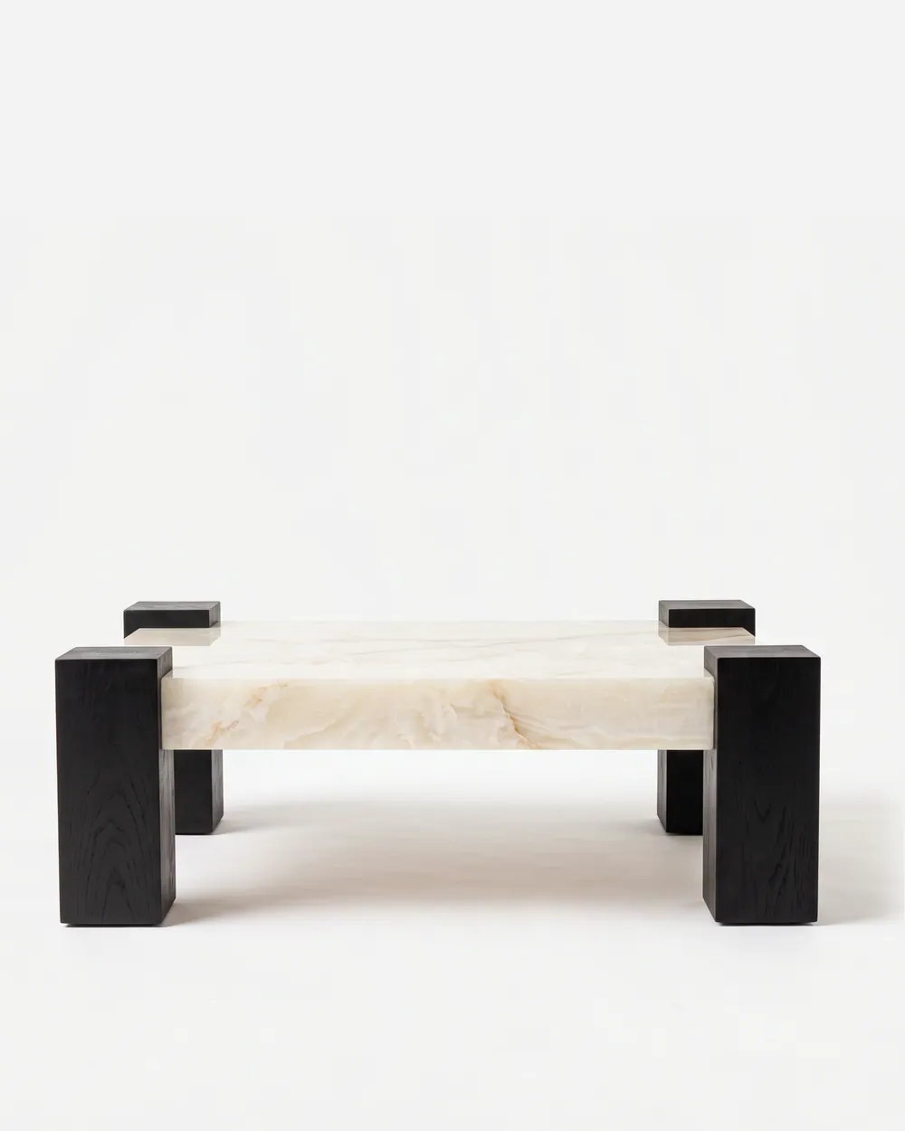 Voss Coffee Table coffee table — square-section corner posts in red oak open grain in a charcoal stain, rising slightly above a thick rectangular top…
