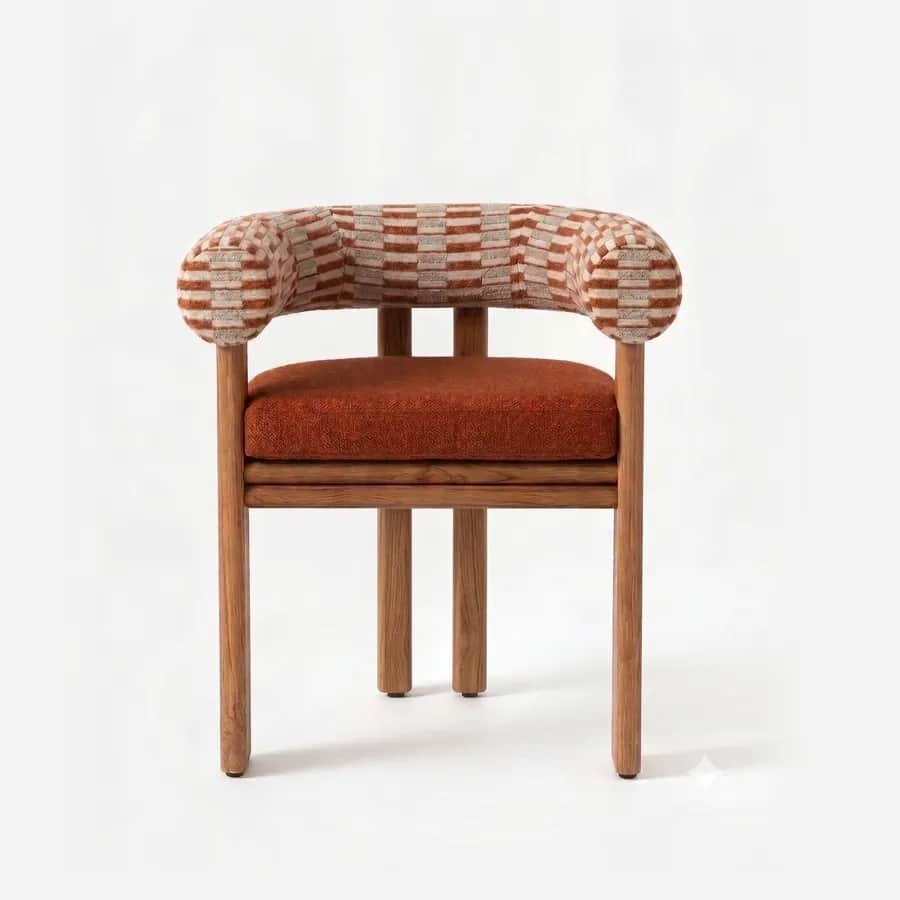 Kaelo Dining Chair dining chair — iroko wood frame on rounded legs with a ringed seat rail, a curved back wrapping into low sides in pattern fabric and…