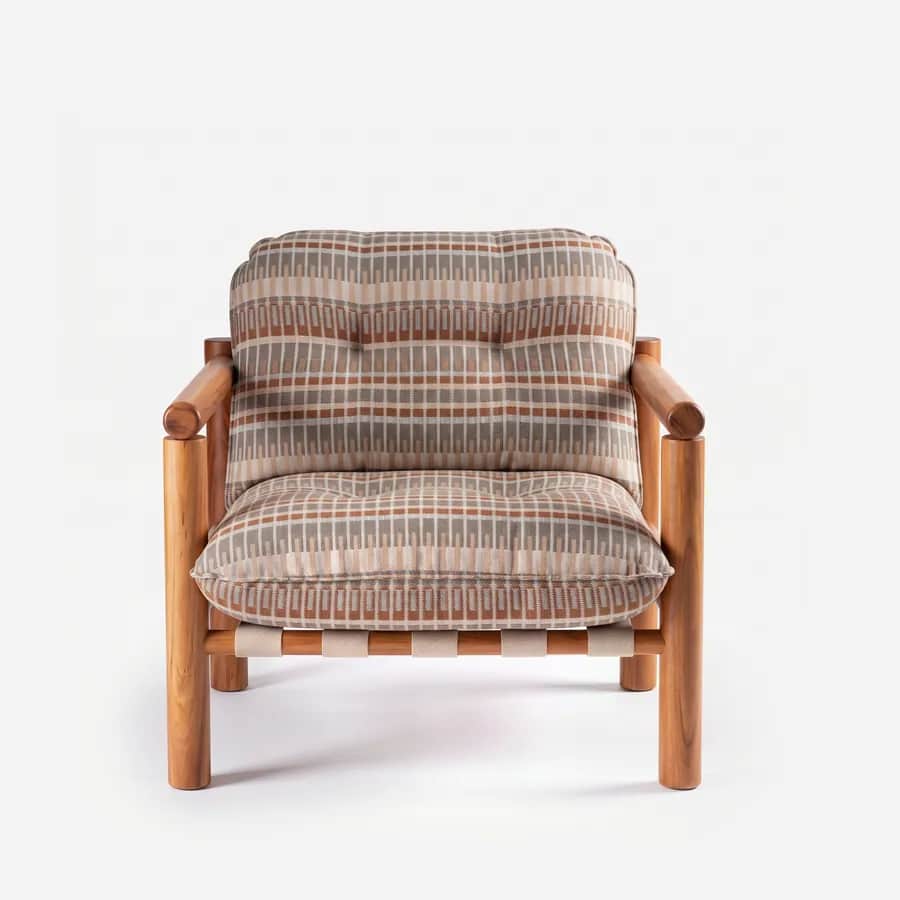 Cael Lounge Chair lounge chair — round-section Iroko wood frame with open arms and a slatted back panel, with a strap-woven seat finished with tufted…