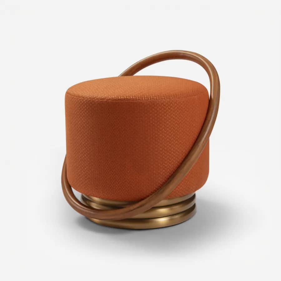 Kora Pouf pouf — a fully upholstered pouf with a patterned fabric seat, complemented by a sculptural wooden ring detail and a brushed…