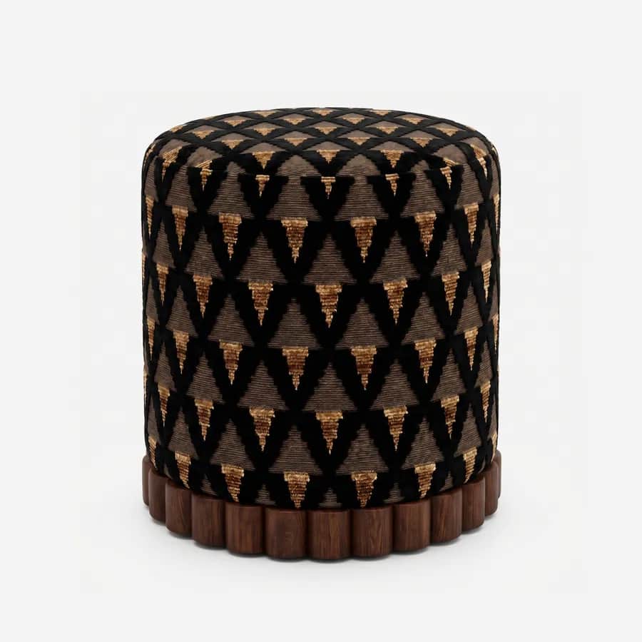 Vela Pouf pouf — walnut wood scalloped, fluted base beneath a cylindrical body upholstered in pattern velvet, with a black triangular…